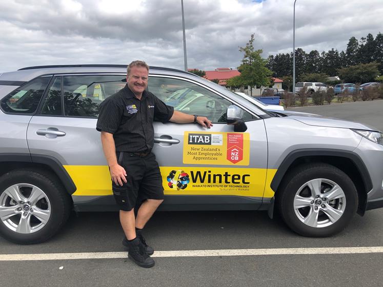Alan Warburton stands in front of his car that has a Wintec and ITAB sticker on the side of it.
