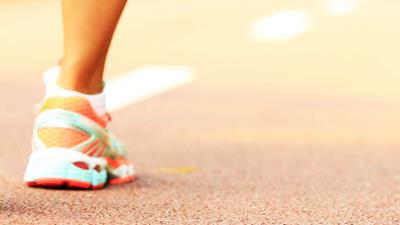 Close up of athlete's shoes as they walk along running track