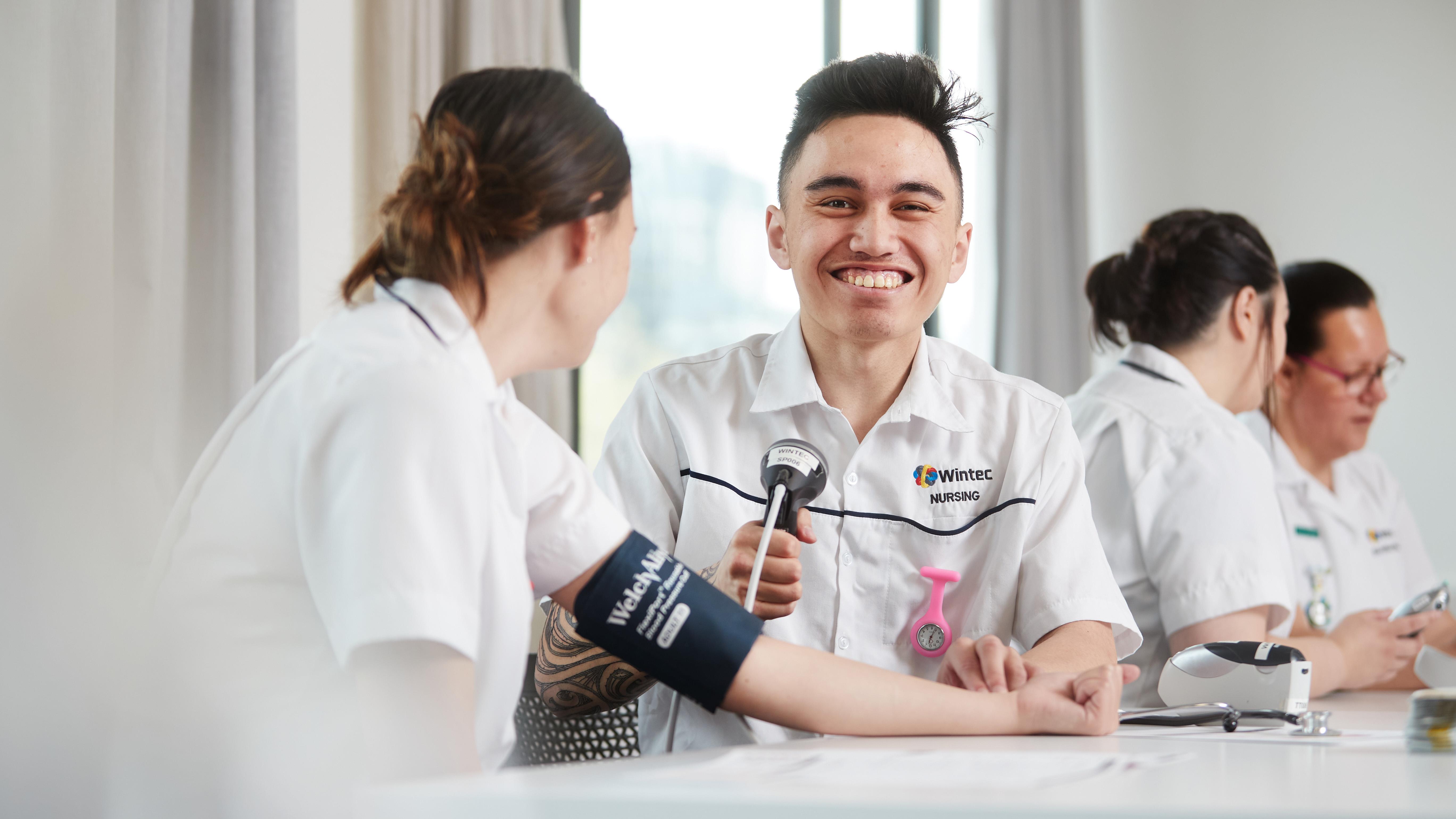 Nursing student taking blood pressure of client