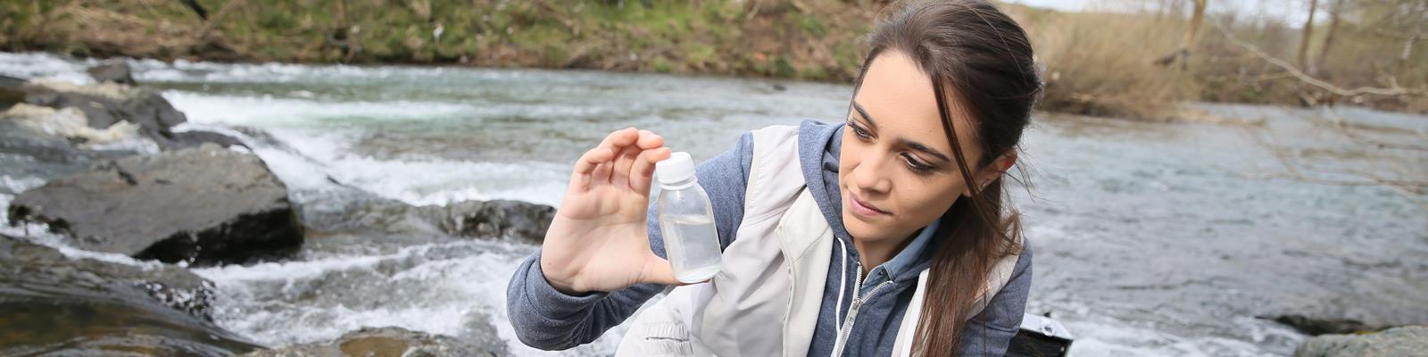 Scientist taking water sample from river