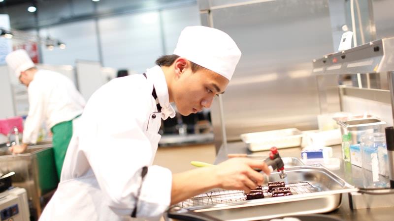 Culinary arts student preparing food in Wintec kitchens